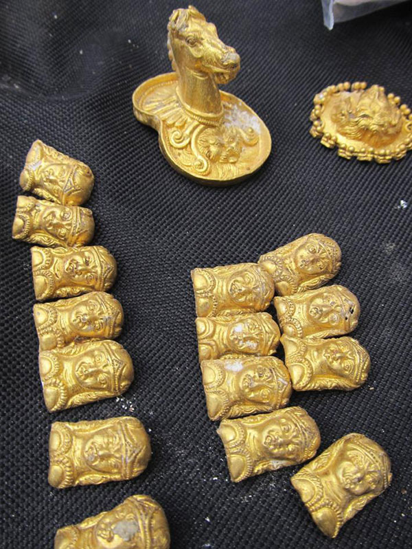 Hoard of Plenty Newly unearthed gold artifacts from a third-century B.C. tomb include a golden horse head, a ring or brooch (top right), and tiny busts of a woman, which likely decorated clothing.