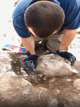 One of the excavation expedition members works to recover the hoard, which was found during construction of a new neighborhood. Image courtesy of the Israel Antiquities Authority.